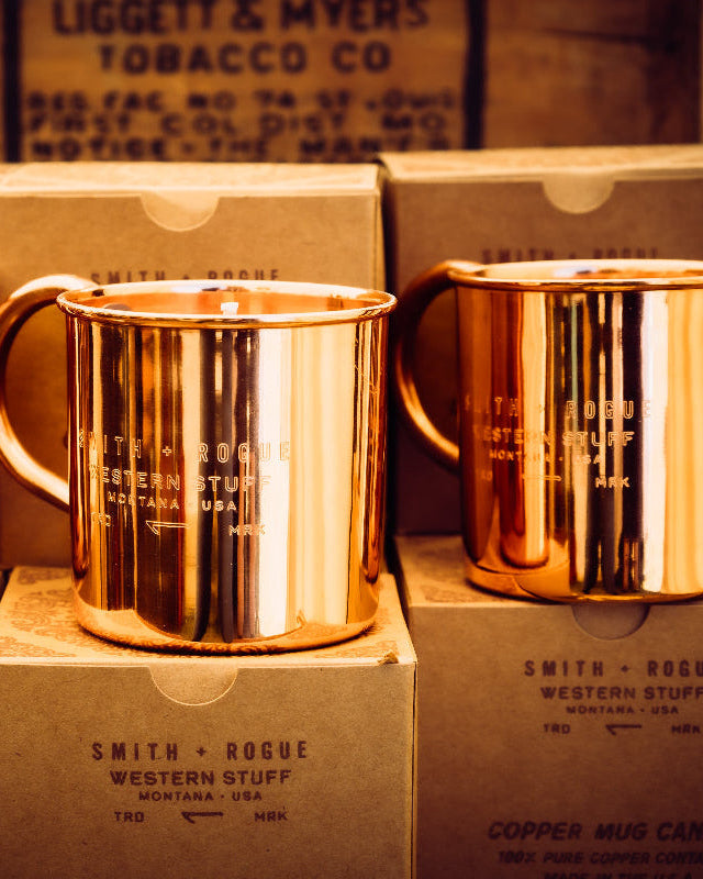 Three copper mugs on cardboard boxes with 'Smith + Rogue' branding.